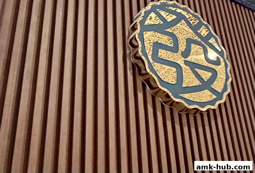 A close-up of a decorative emblem with blue and gold patterns on a ribbed wooden background.