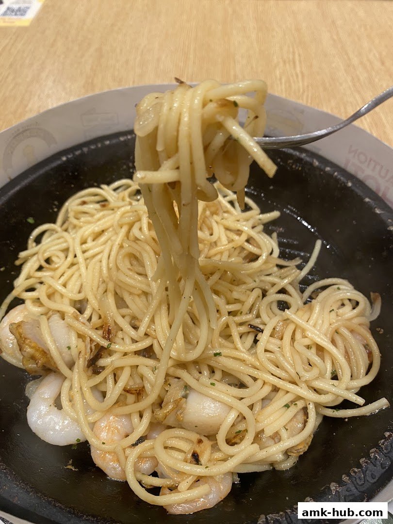 A close-up shot of a steaming hot seafood pasta dish being lifted by a fork.