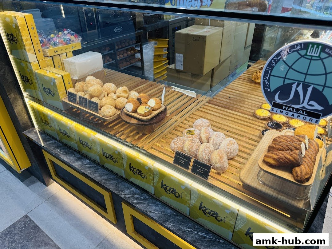 A display case filled with various baked goods, including pastries and buns, at a Kazo shop.