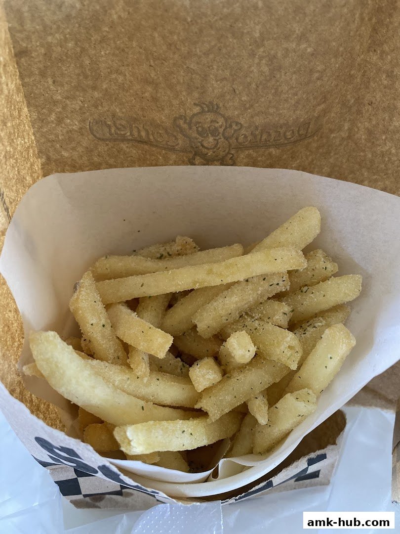 A close-up shot of a paper bag filled with seasoned french fries from Potato Corner.