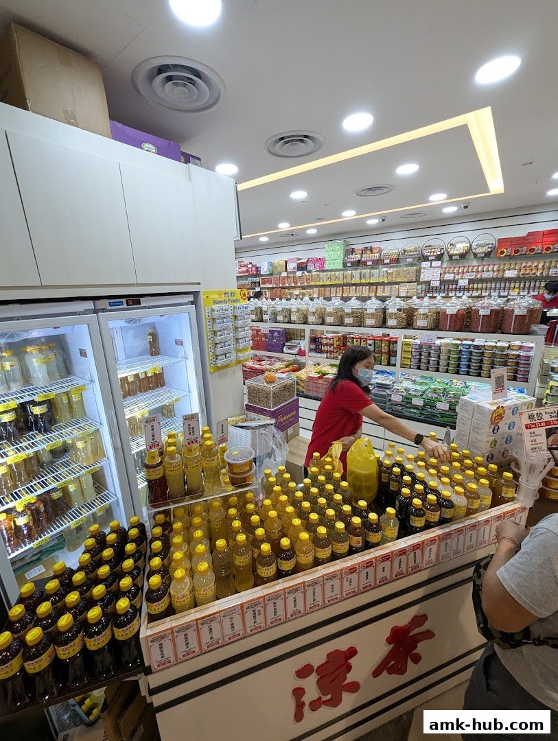 A store interior with a wide selection of bottled tonics and dried goods, and a staff member assisting a customer.