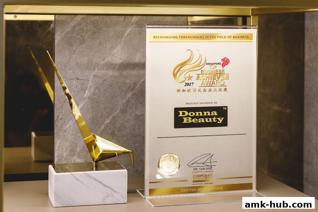 A gold award trophy and a certificate for Donna Beauty, a Singapore Top Business Achiever.