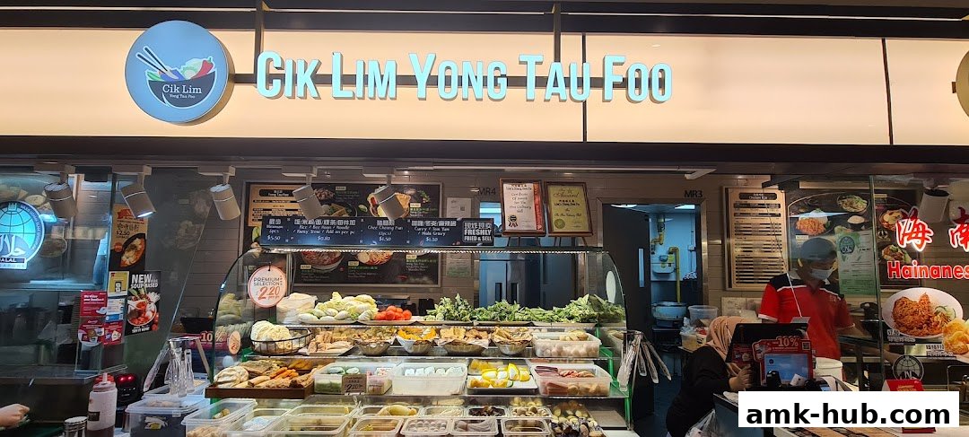 A food stall named Cik Lim Yong Tau Foo displaying a variety of fresh ingredients and prepared dishes.