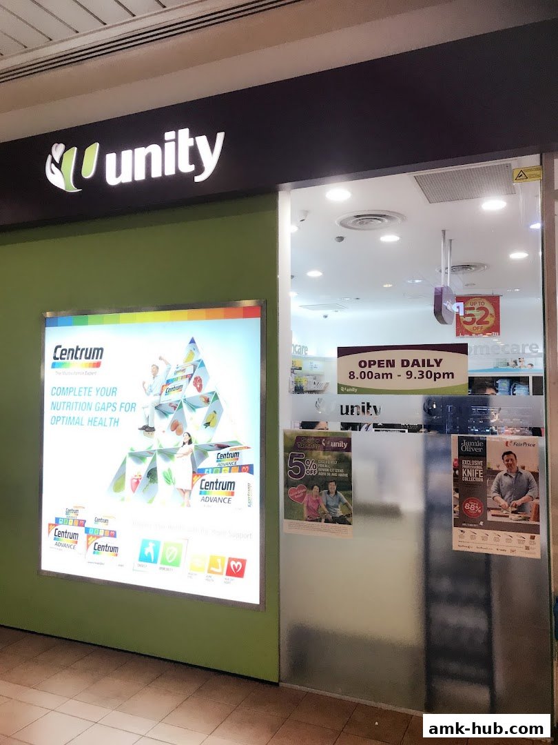 The exterior of a Unity pharmacy shop with a large illuminated advertisement for Centrum.