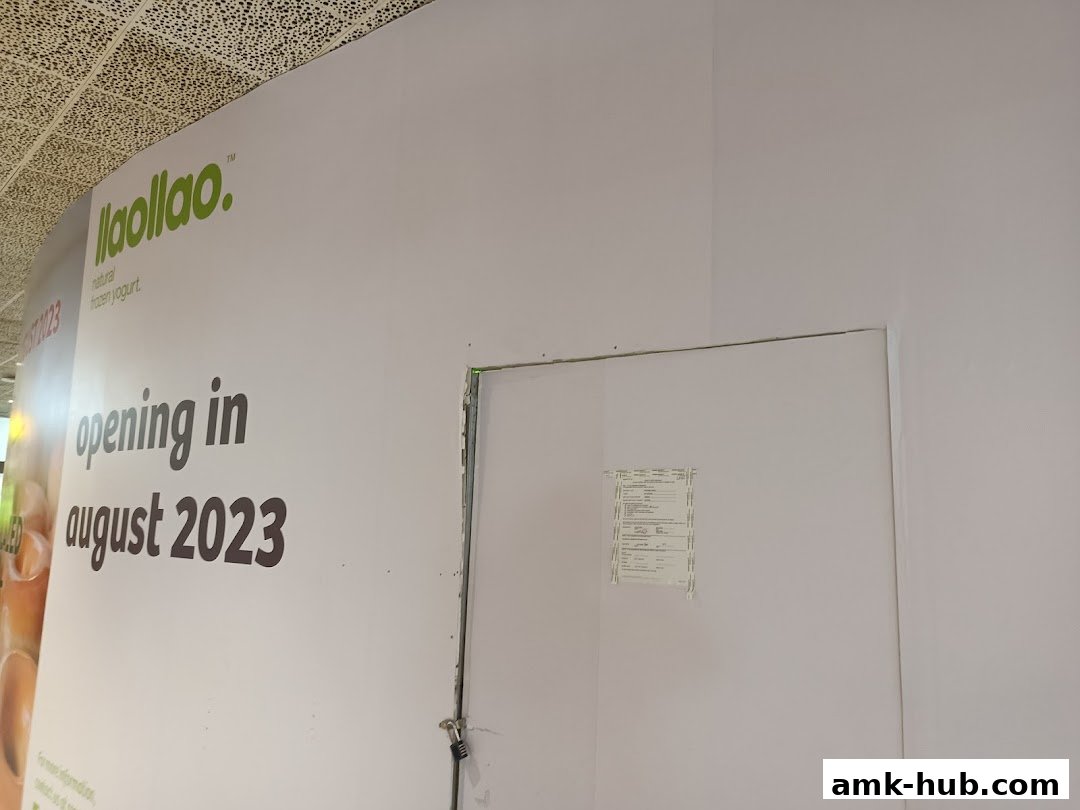 A wall with the llaollao logo and 'opening in august 2023' text.