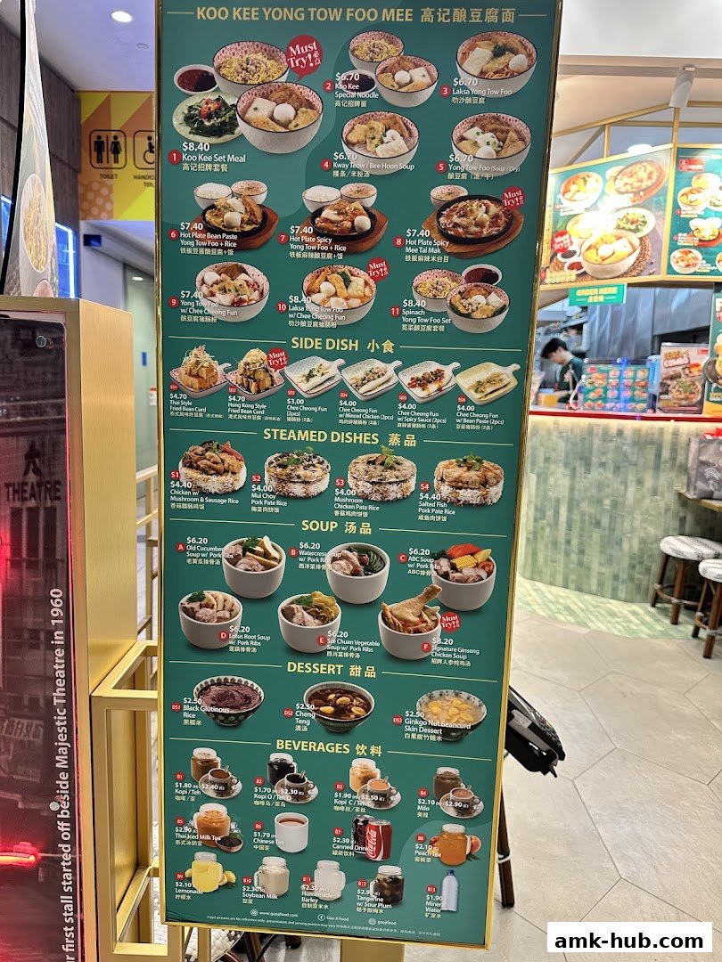 A menu board for Koo Kee Yong Tow Foo Mee, showcasing various noodle dishes, side dishes, soups, desserts, and beverages.