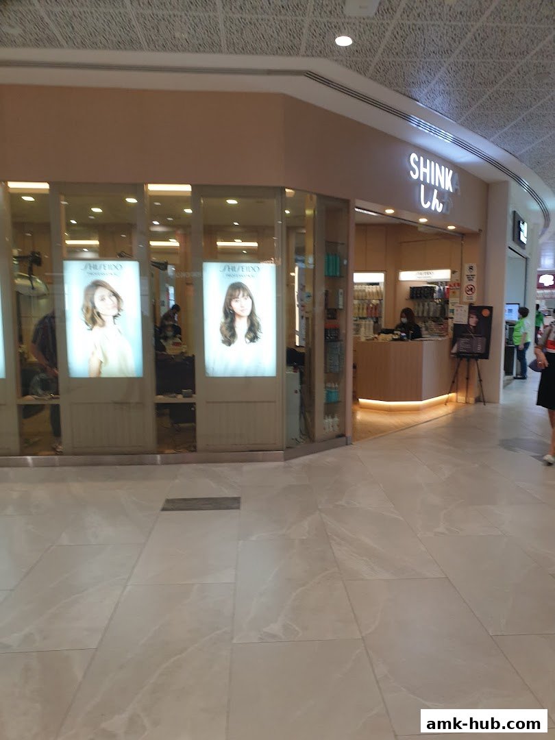 The Shinka shop front features illuminated displays of hairstyles and a welcoming reception area.