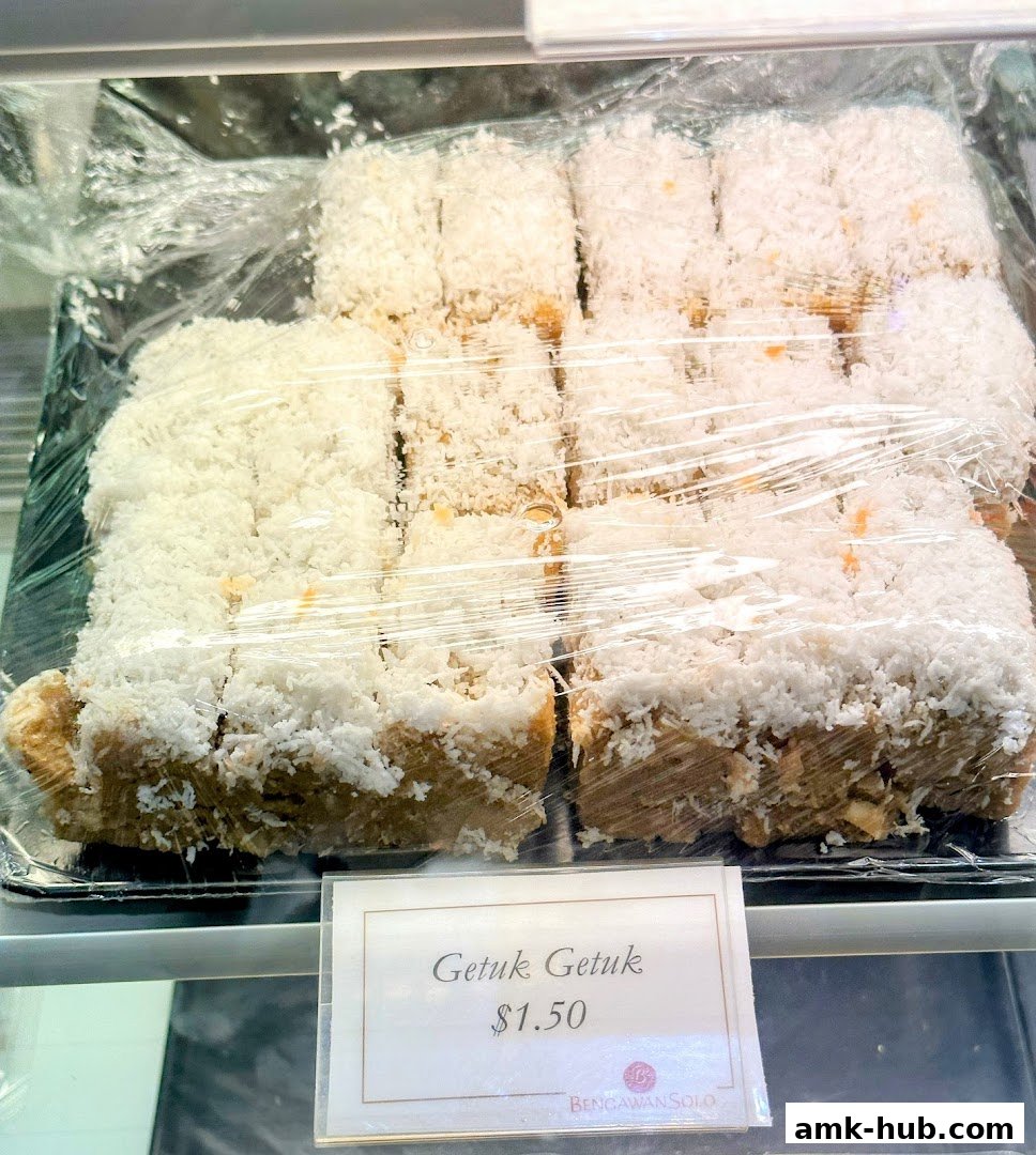 A close-up of Getuk Getuk pastries covered in shredded coconut, priced at $1.50.