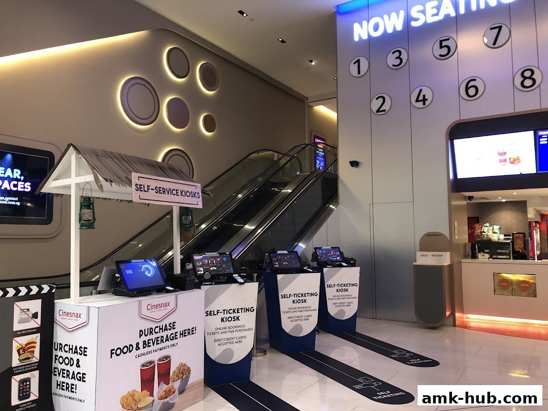Self-service kiosks and a concession counter at a cinema entrance.