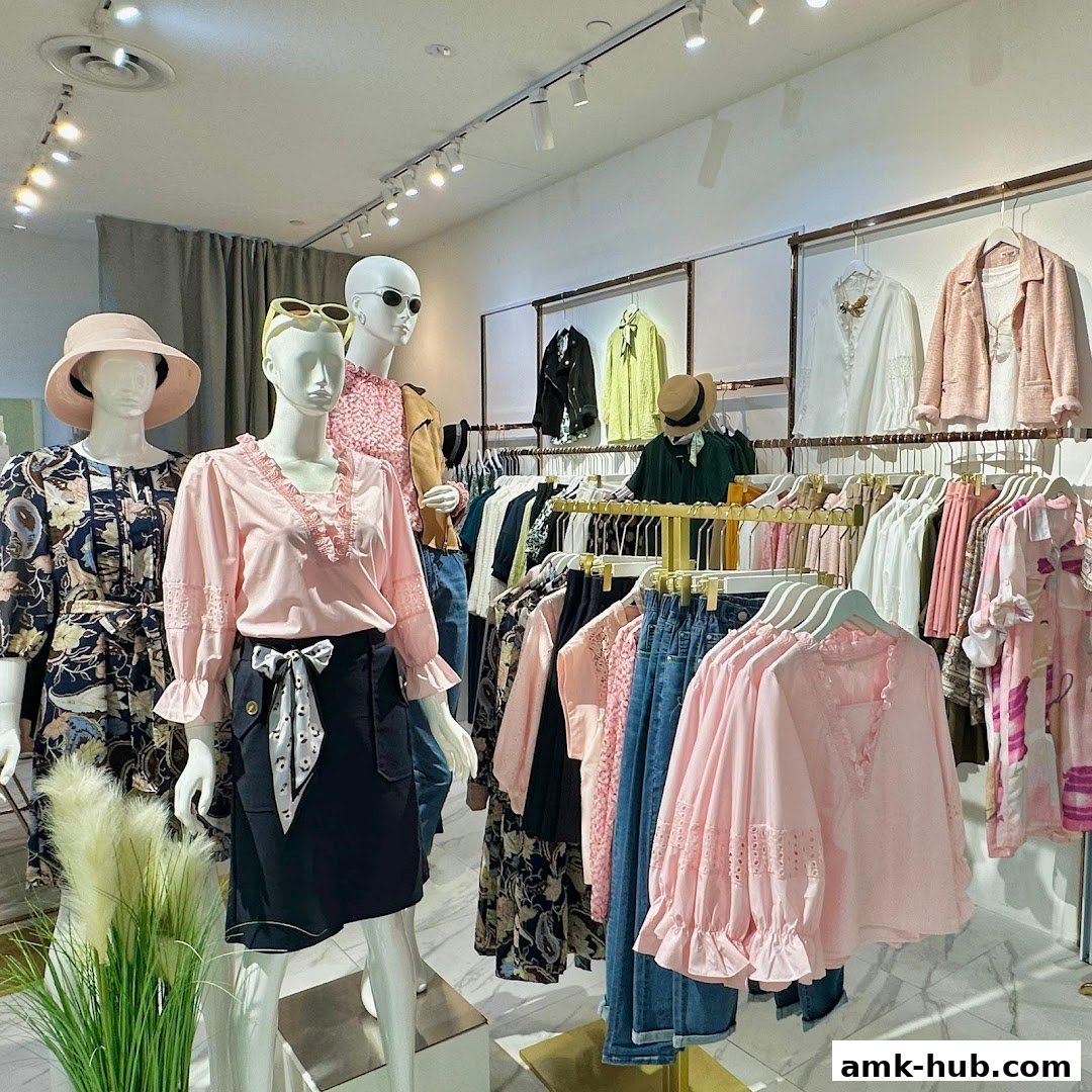 Mannequins display stylish women's clothing, including blouses, skirts, and jackets, with racks of apparel in the background.