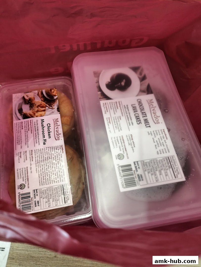 Two containers of Melvados food products, Chicken Mushroom Pie and Chocolate Melt Lava Cakes, inside a red bag.