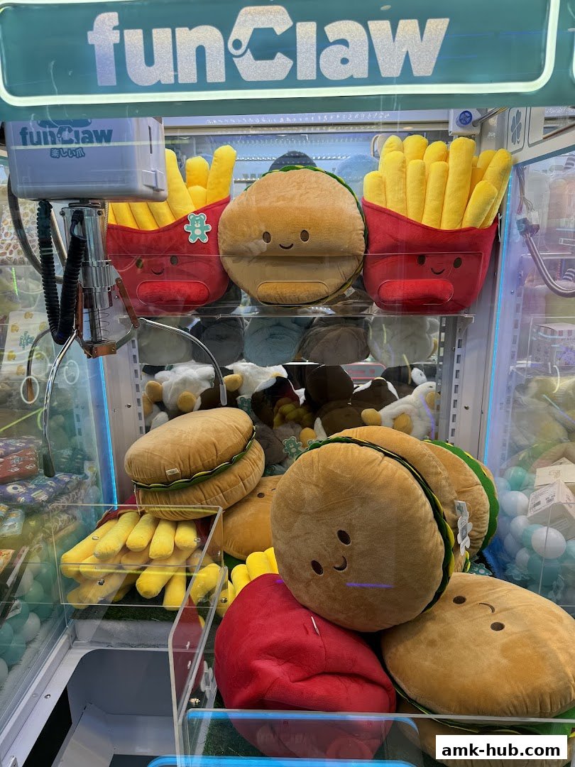 A claw machine filled with plush toys shaped like burgers, fries, and other food items.