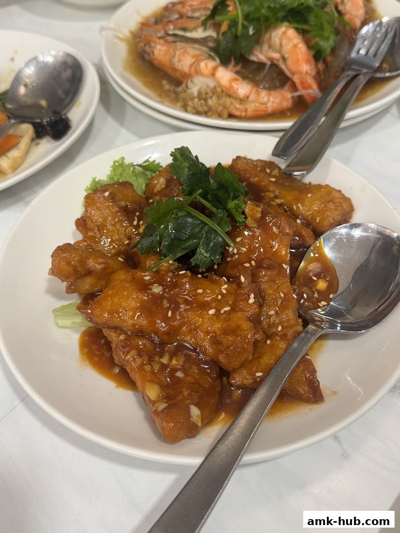 A plate of delicious sweet and sour chicken with sesame seeds and cilantro.