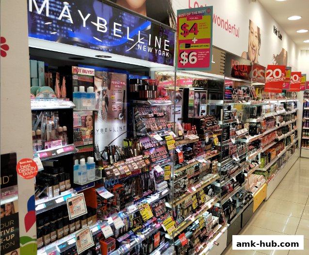 A wide selection of makeup and beauty products displayed on shelves in a retail store.