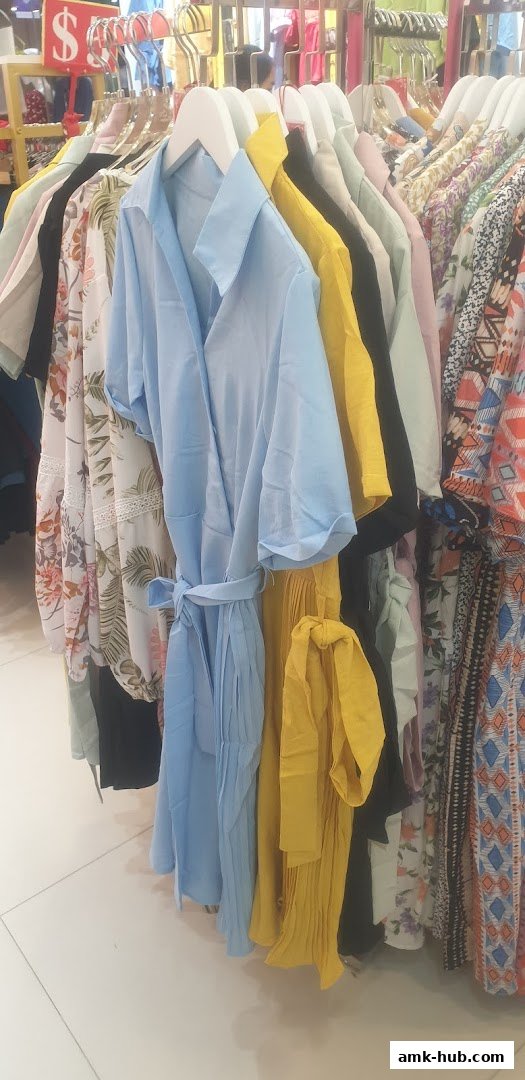 A rack of colorful women's clothing, featuring dresses and patterned tops.