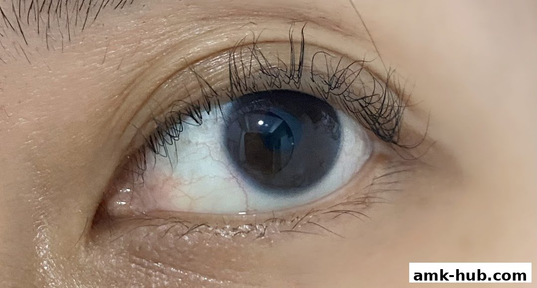 A close-up shot of a human eye with dark iris and long eyelashes.