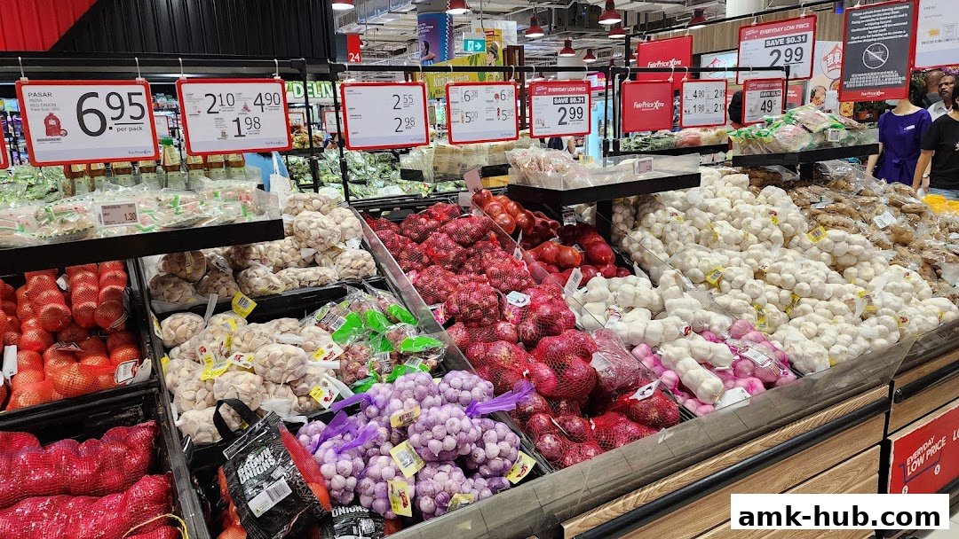A display of fresh produce including onions, garlic, and other vegetables at a supermarket.