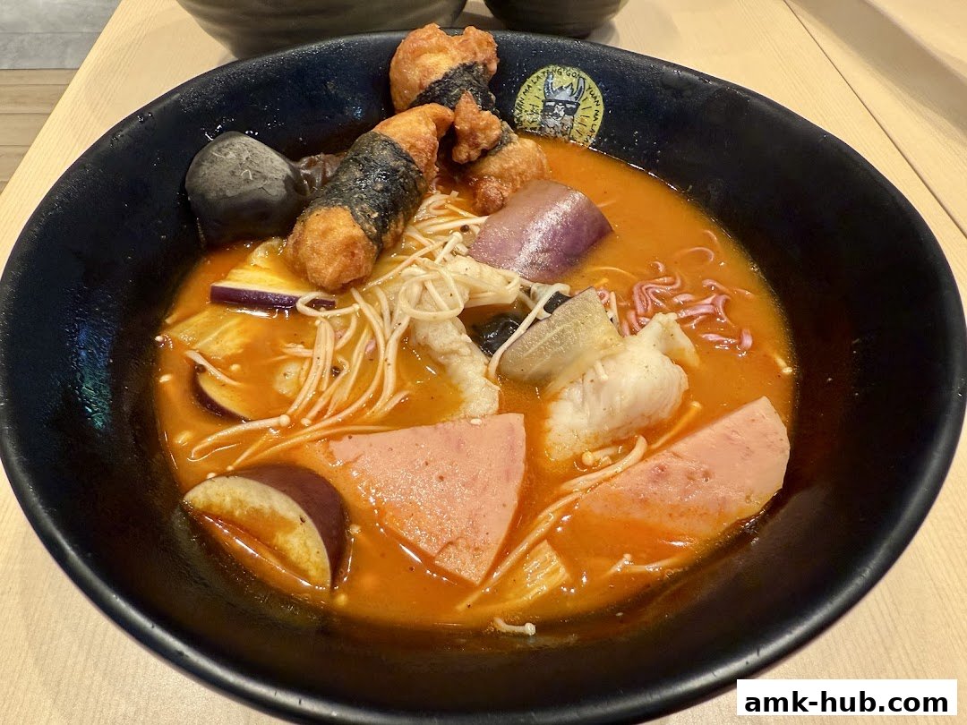 A close-up of a steaming bowl of Mala Tang with various ingredients like fish, eggplant, and fried items.