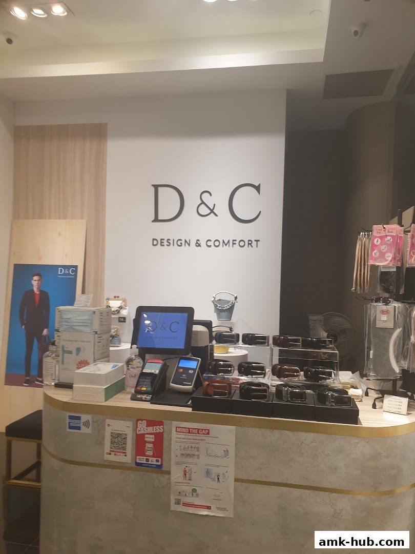 A retail counter displaying belts, payment terminals, and promotional materials for D&C.
