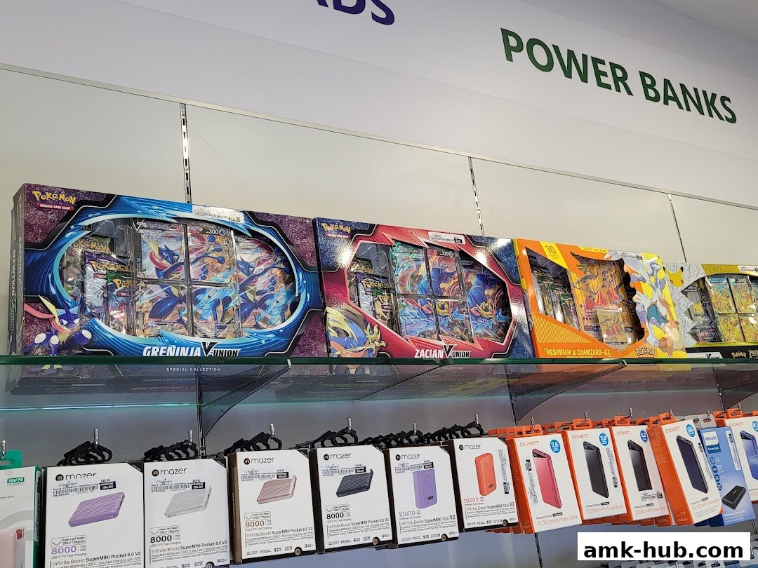 Shelves display Pokémon trading card game special collections and various power banks.
