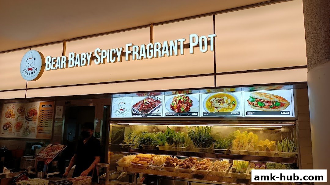 A brightly lit shop front for 'Bear Baby Spicy Fragrant Pot' with a menu display and fresh ingredients.