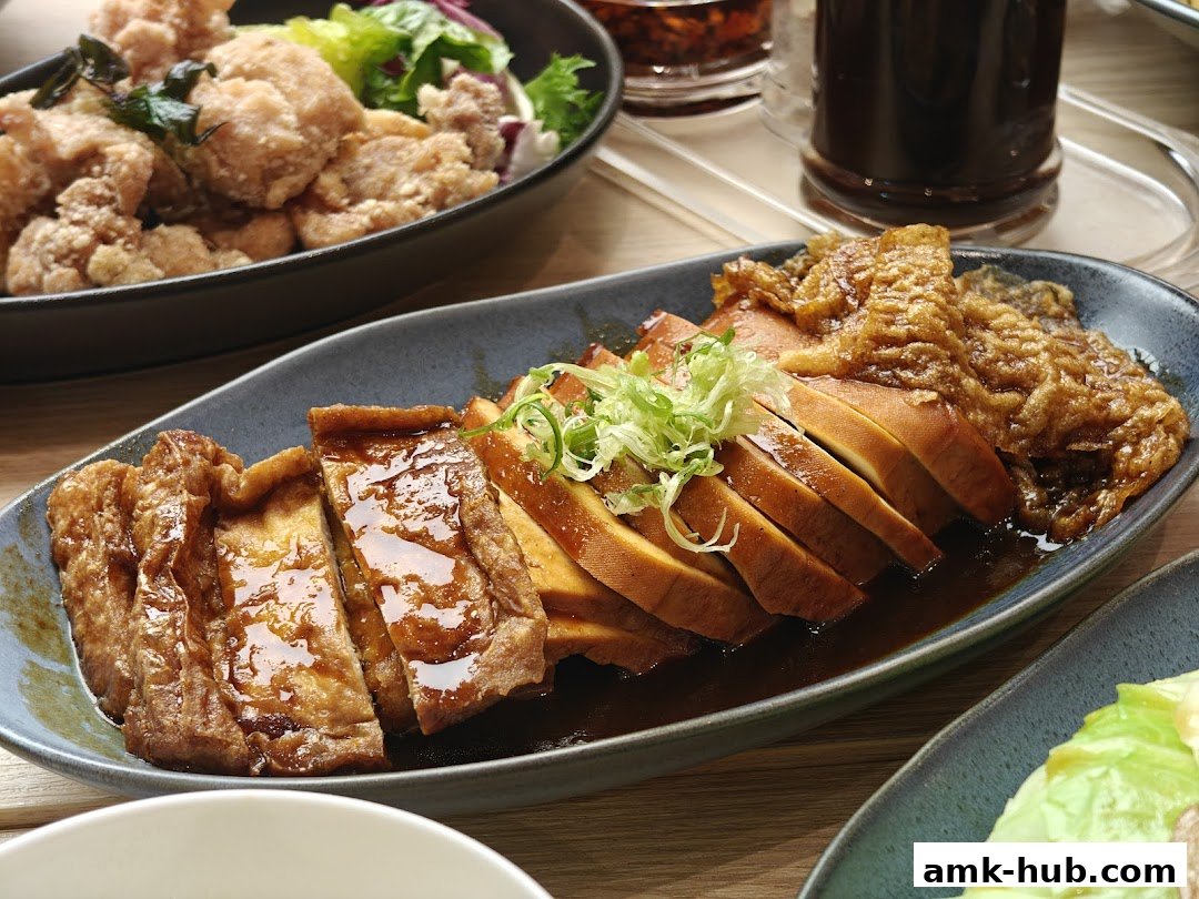 A close-up of delicious braised tofu and fried chicken with a side of salad.