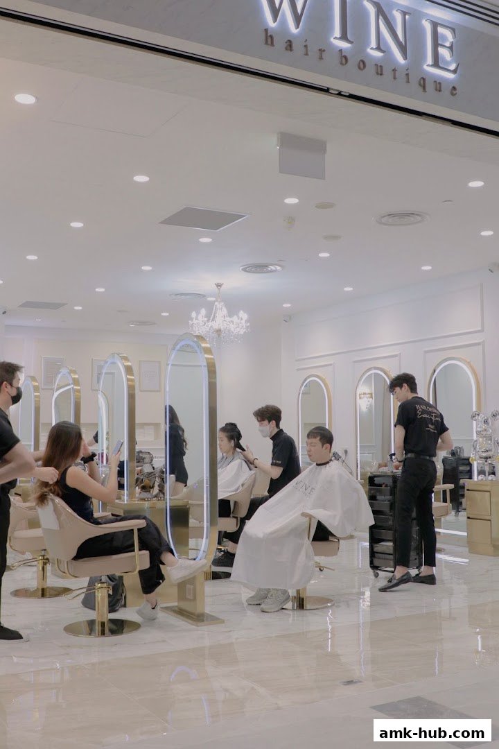 Hair stylists working on clients in a modern, well-lit hair salon.