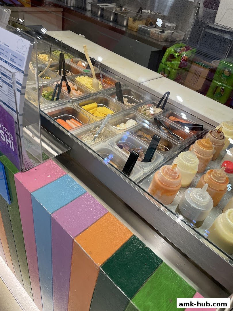 A display case filled with various sushi ingredients and sauces at Maki-San.