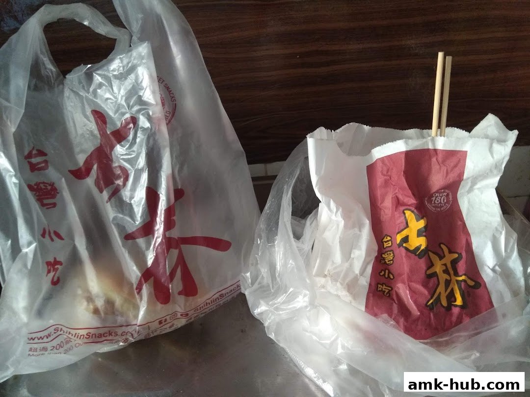 Two plastic bags from Shihlin Taiwan Street Snacks containing food and chopsticks.