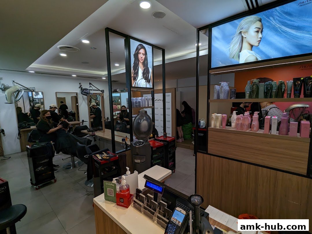 Interior of a hair salon with stylists working on clients and retail products on display.
