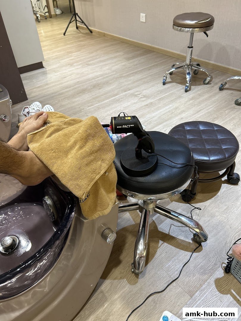A person's foot is being pampered in a pedicure chair with a towel.