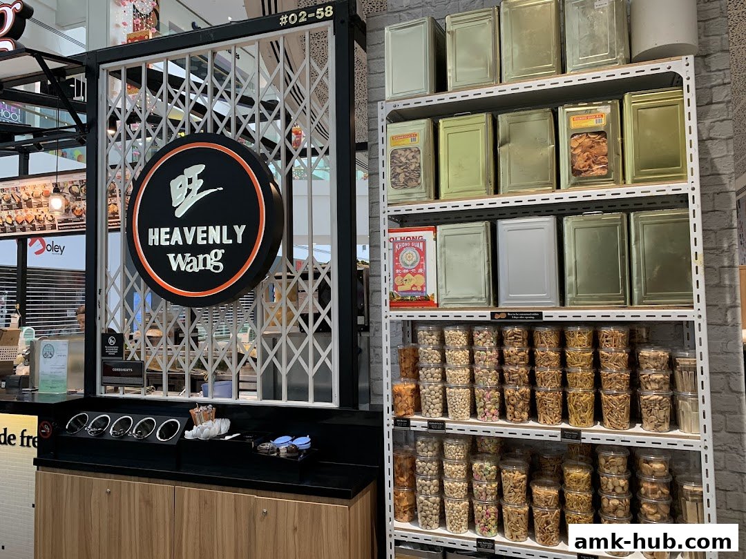 The Heavenly Wang shop front displays a prominent circular logo and shelves stocked with various snacks in tins and containers.