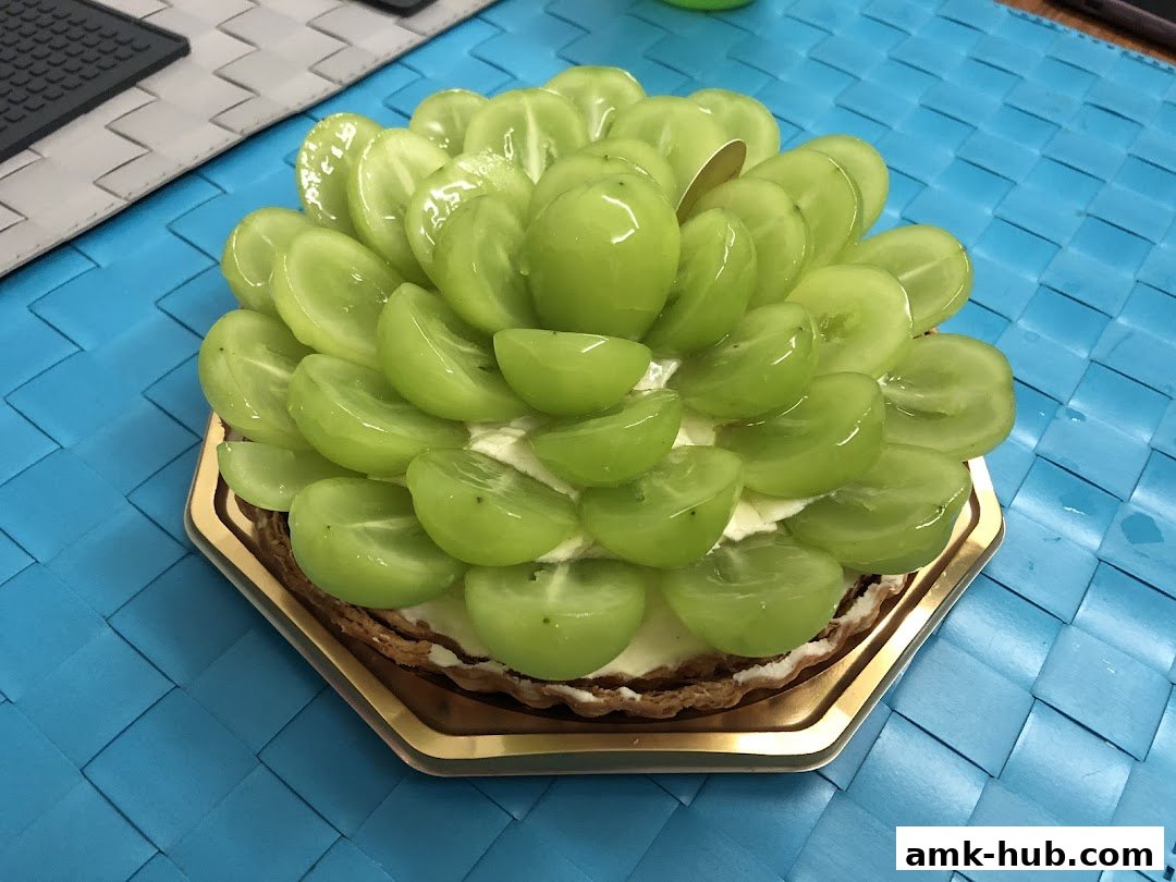 A delicious tart topped with fresh, sliced green grapes and cream.