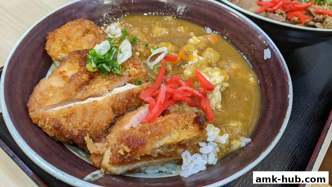 A close-up of a delicious chicken katsu curry with rice, garnished with spring onions and pickled ginger.