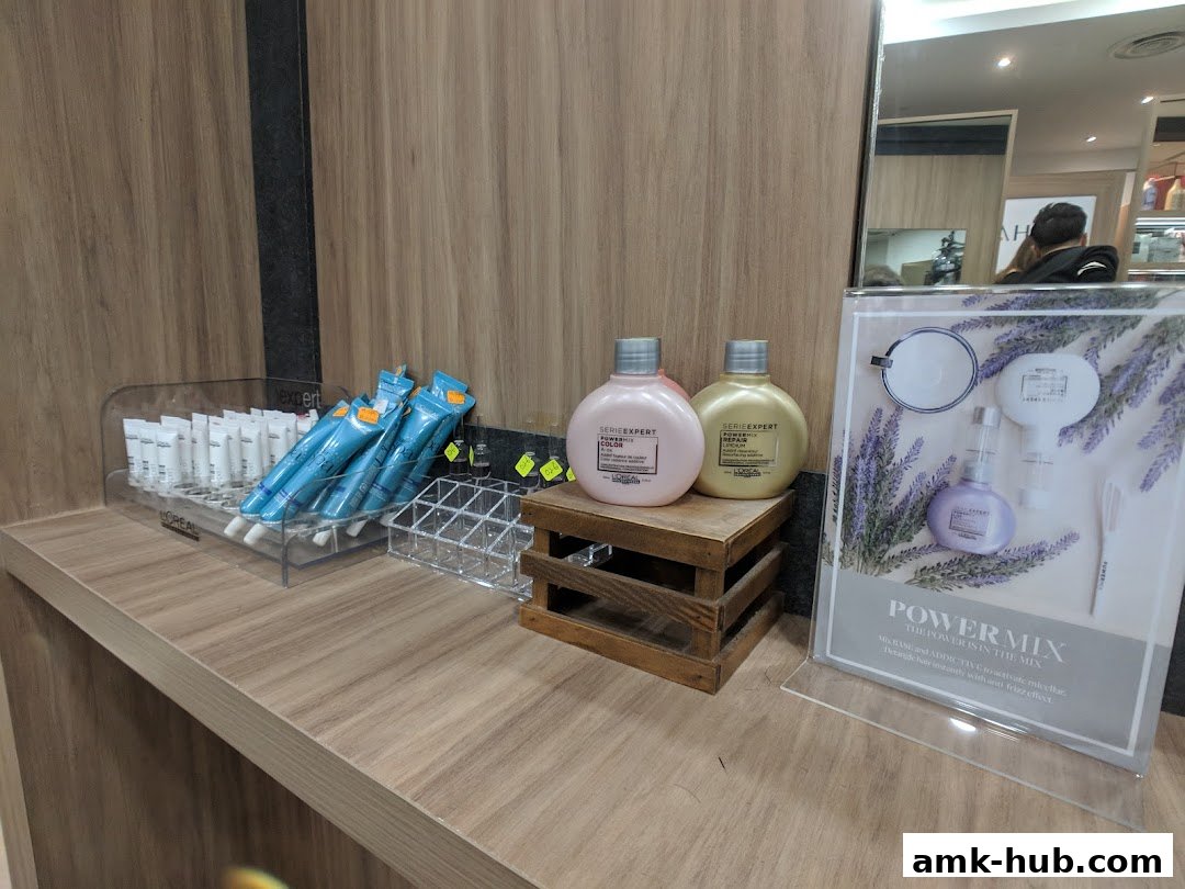 Hair products displayed on a shelf, including L'Oréal Serie Expert bottles and tubes.