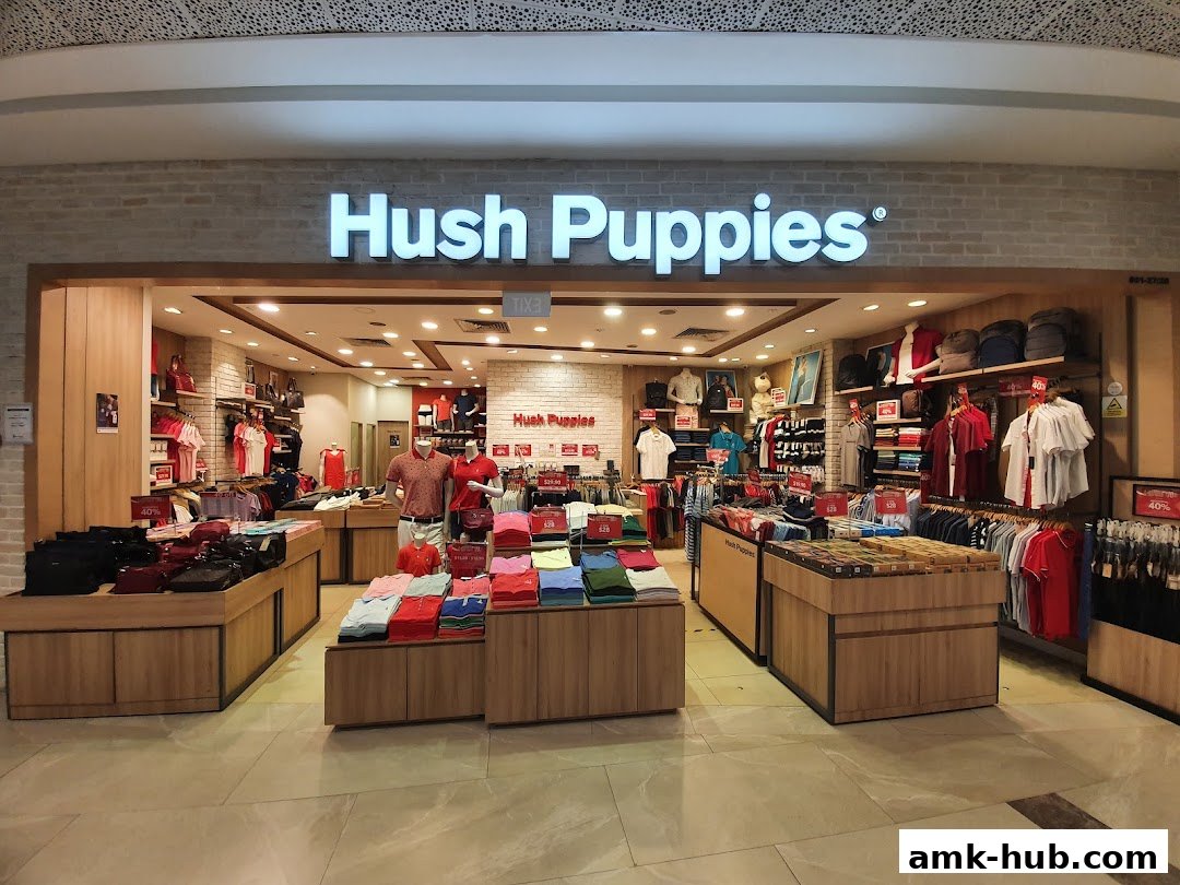 The Hush Puppies store entrance showcases a variety of apparel and accessories displayed on shelves and racks.