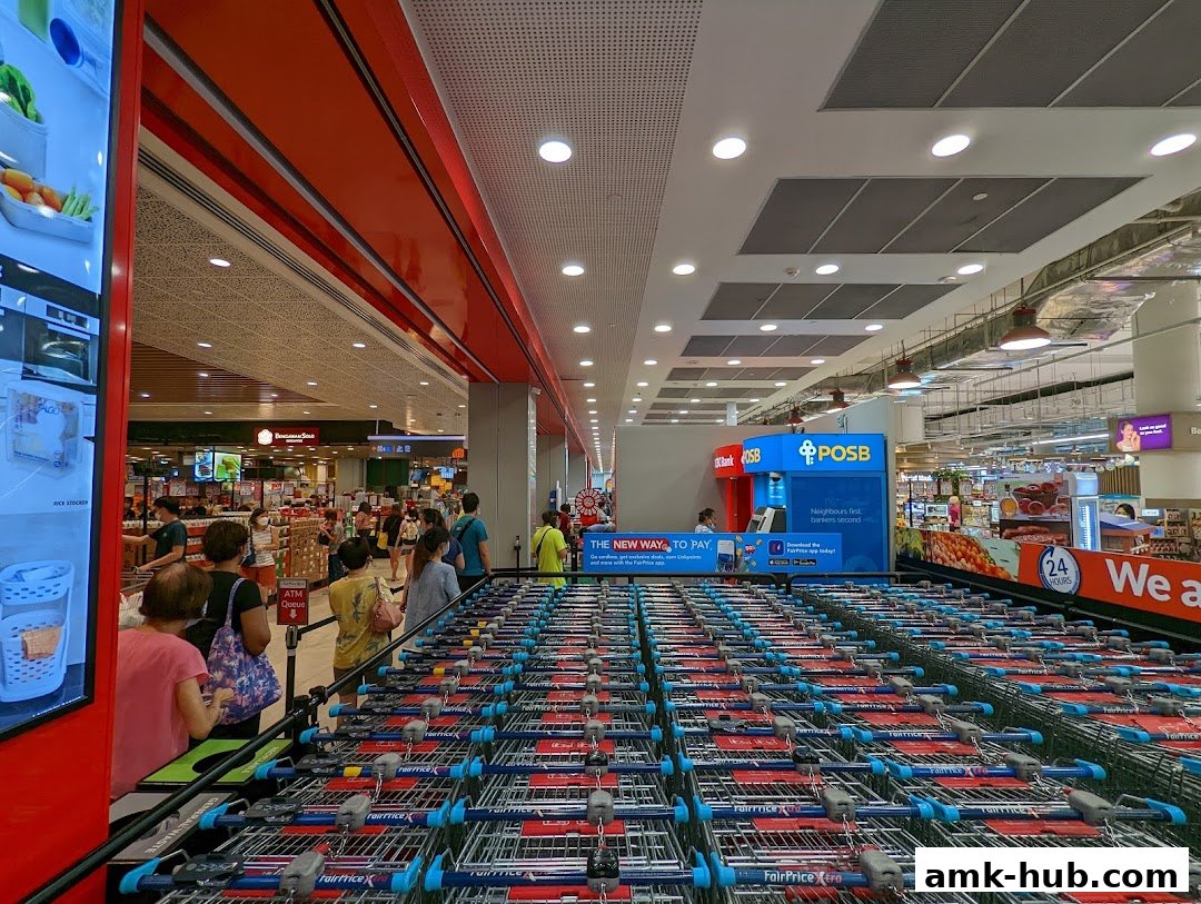 Rows of shopping carts in front of a FairPrice Xtra supermarket with an ATM.