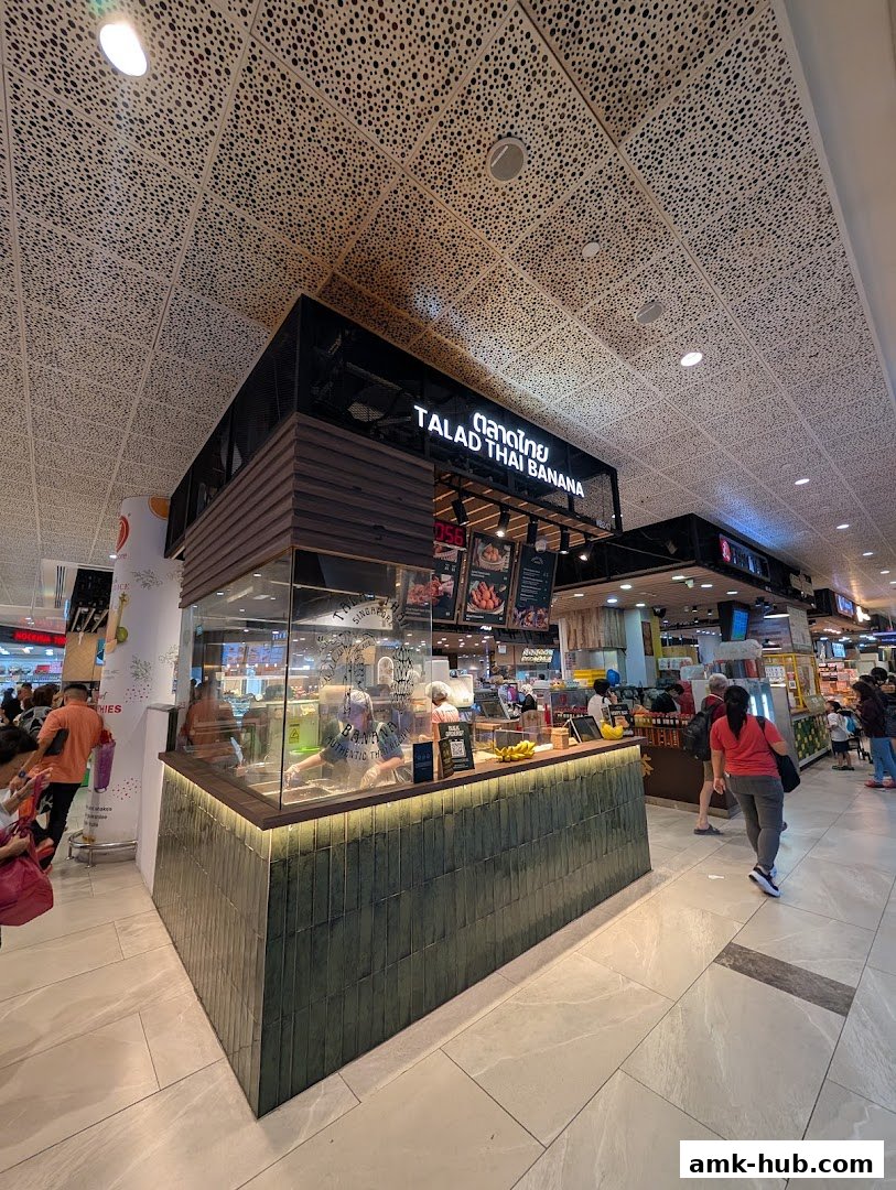 A modern Thai food stall with a clean counter and visible staff preparing food.