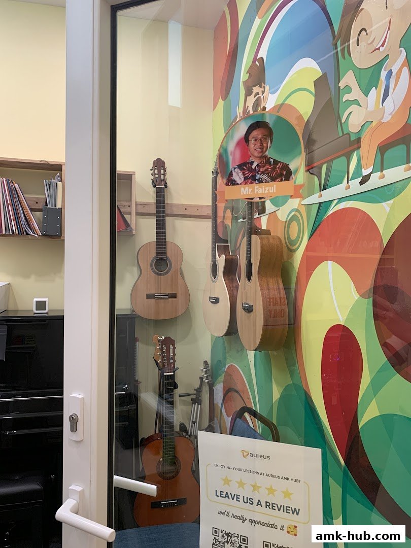 Interior view of Aureus Academy with guitars displayed and colorful wall art.