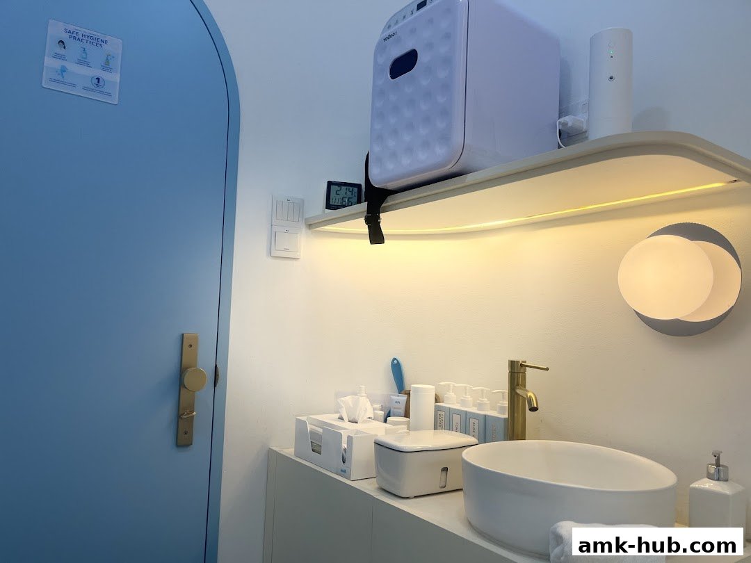 A clean and modern washroom area with a sink, toiletries, and a blue door.