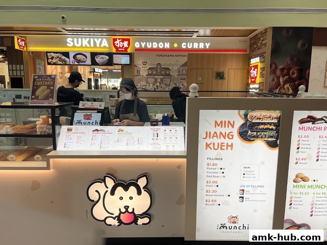 A food stall with a menu displaying pancakes and other items, with staff serving customers.