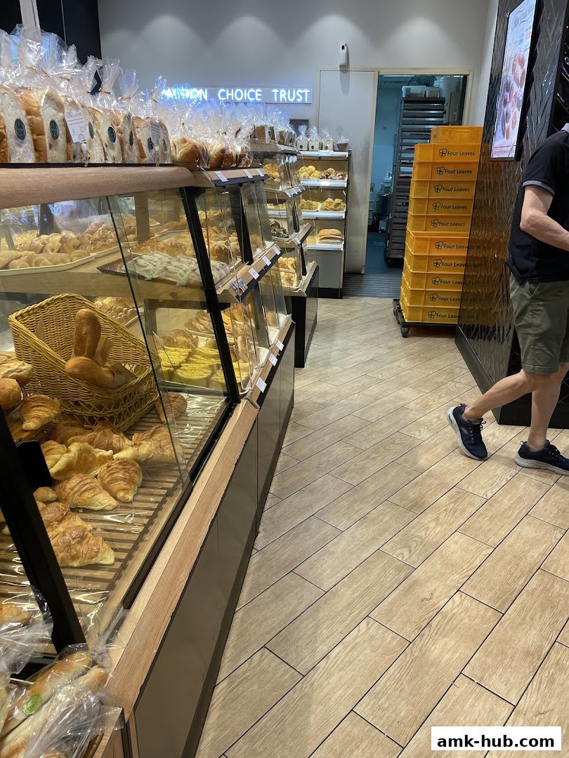 Interior view of a bakery with display cases full of bread and pastries.