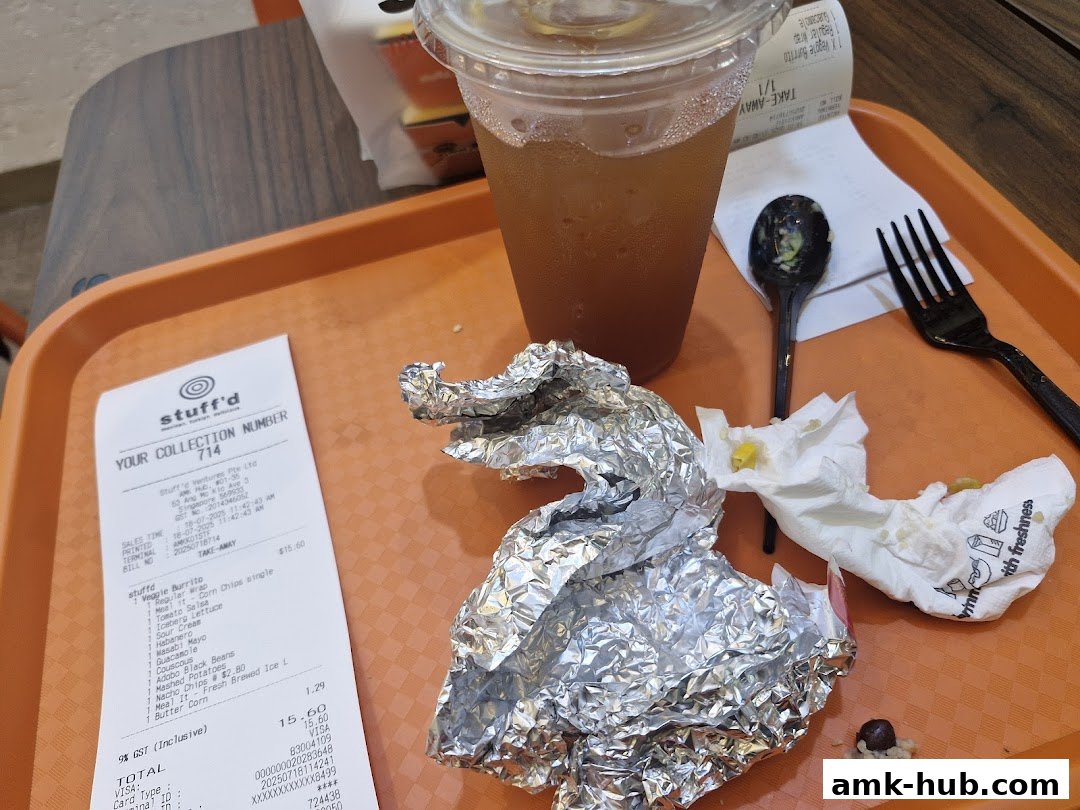 A tray with a drink, receipt, and partially eaten food from Stuff'd.