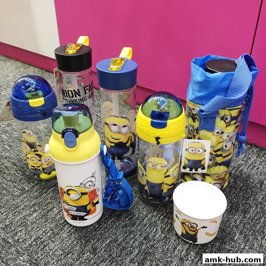 A collection of Minions-themed water bottles and a cup displayed on a carpeted surface.