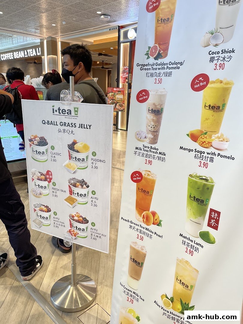 A menu board displaying various i-tea drinks and their prices, with images of the beverages.