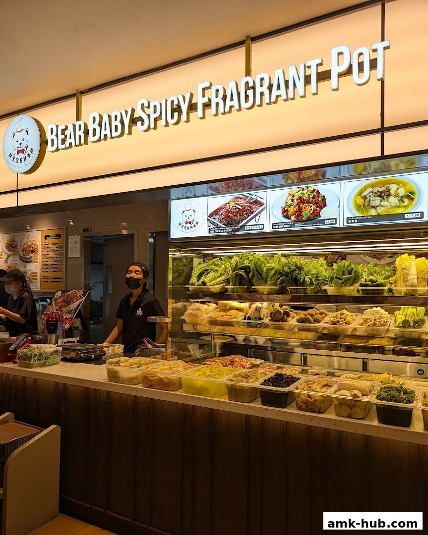 A food stall with a variety of fresh ingredients and prepared dishes, with staff serving customers.