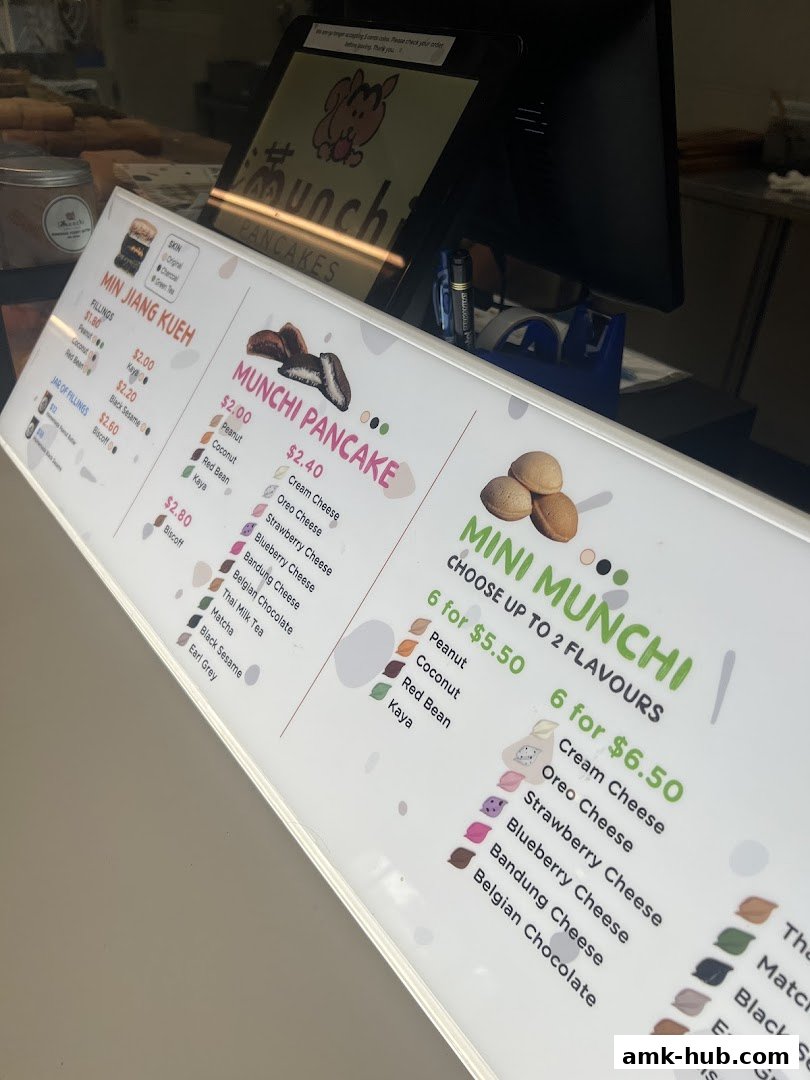 A menu board for Munchi Pancakes displaying various pancake flavors and fillings.