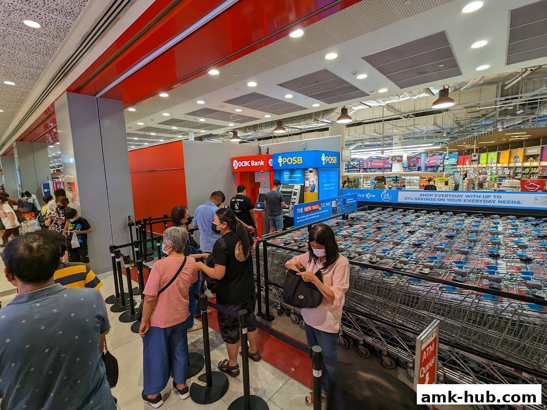 People queuing at an OCBC ATM and POSB machines inside a Fairprice Xtra supermarket.