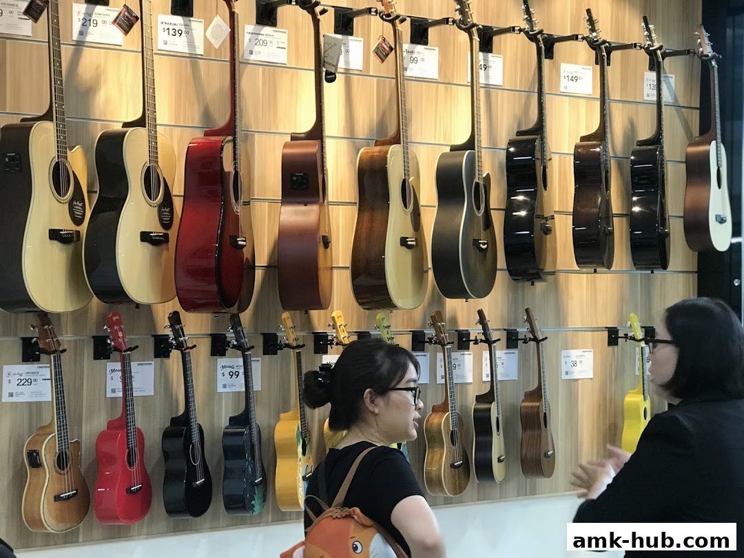 Two people are looking at a wall display of guitars and ukuleles at a music school.