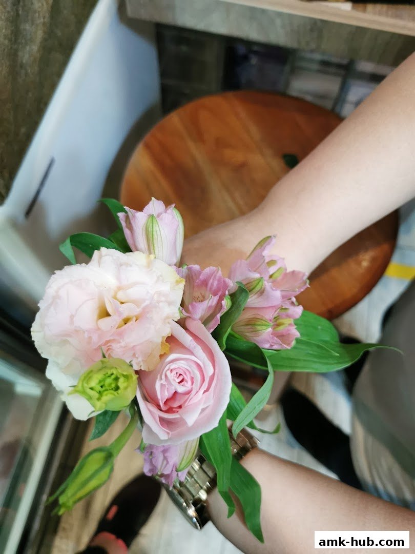 A close-up of a delicate bouquet of pink and white roses and lilies.